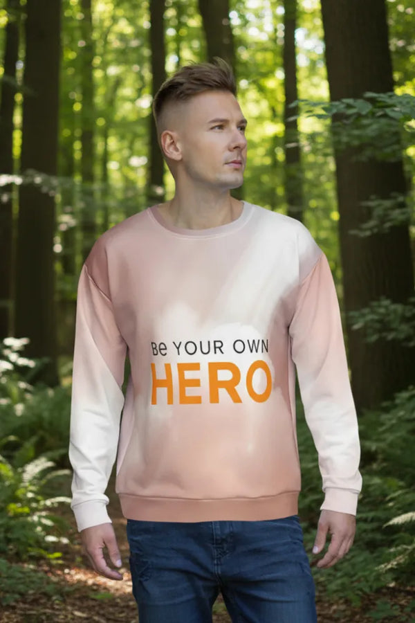 Man wearing a sweatshirt with 'Be Your Own Hero' text in a forest setting