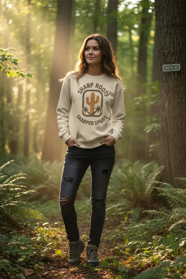 Woman wearing a 'Sharp Roots' hoodie in a forest setting