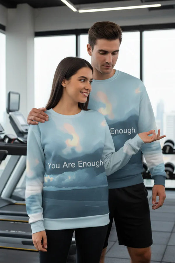 Two people wearing matching 'You Are Enough' sweatshirts in a gym setting.