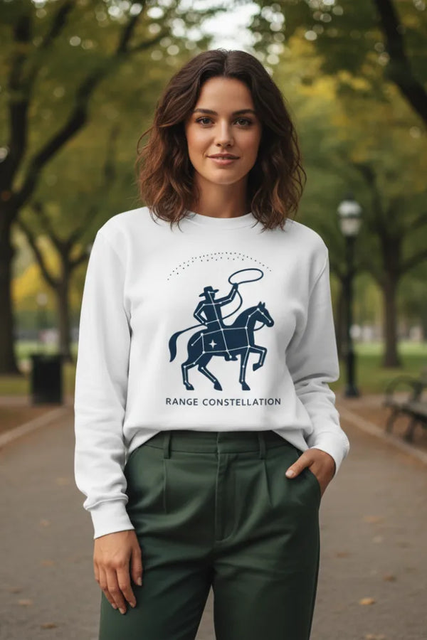 Woman wearing a white sweatshirt with a graphic design and text, standing in a park.