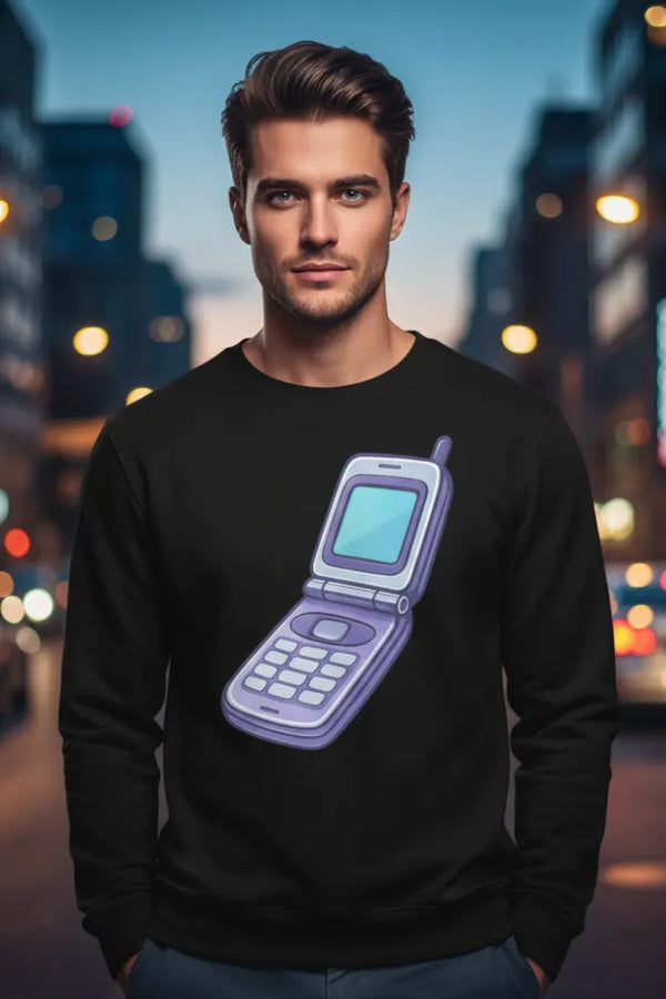 Man wearing a black sweatshirt with a graphic of an old-style phone on a city street at night.