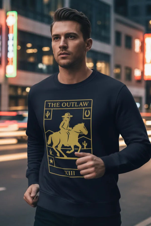 Man wearing a black sweatshirt with 'The Outlaw' graphic design in an urban setting