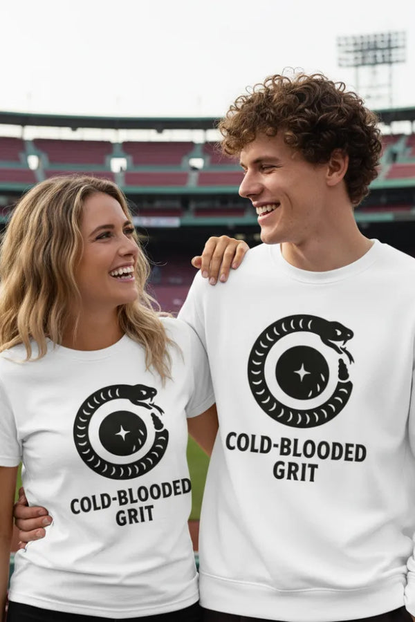Two people wearing white shirts with a snake logo and 'Cold-Blooded Grit' text, standing in front of a stadium.