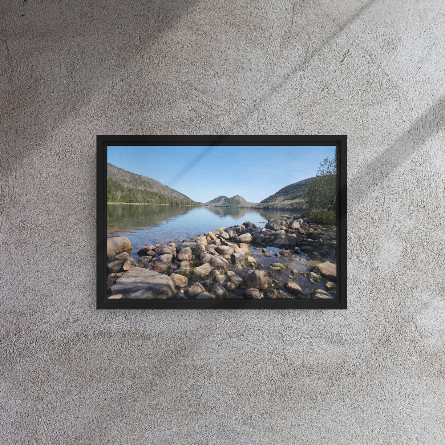 Framed canvas print of Bar Harbor, Maine's Jordan Pond with rocky shoreline, calm reflective water, and surrounding mountains under a clear blue sky.