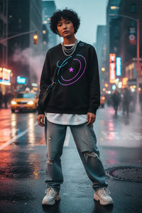Person wearing a black sweatshirt with colorful designs on a city street at night.