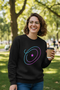 Person wearing a black sweatshirt with a colorful design, holding a coffee cup outdoors.