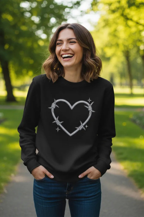 Woman wearing a black sweatshirt with a heart design outdoors