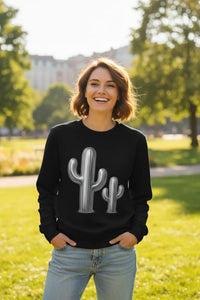 Person wearing a black sweatshirt with a cactus design outdoors