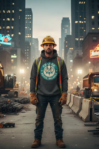Person wearing a hard hat and gloves standing on a construction site with city skyline in the background