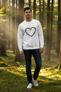 Man wearing a white sweatshirt with a heart design in a forest