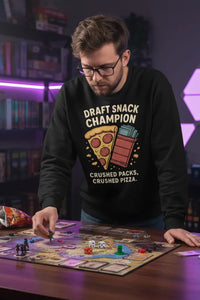 Man playing a board game wearing a black sweatshirt with a humorous graphic design.