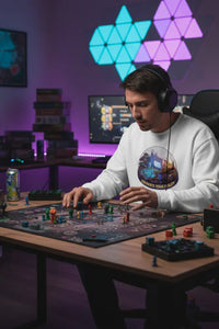 Person playing a board game with colorful LED lights in the background