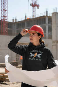 Person wearing a hard hat and hoodie with construction equipment in the background
