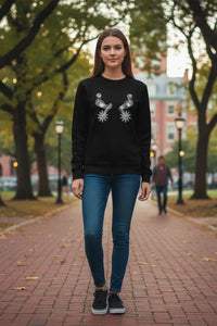 Woman wearing a black sweatshirt with a graphic design in an outdoor setting