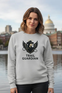 Woman wearing a gray sweatshirt with 'Trail Guardian' design in front of a cityscape.