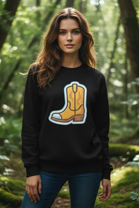 Woman wearing a black sweatshirt with a yellow boot design in a forest setting