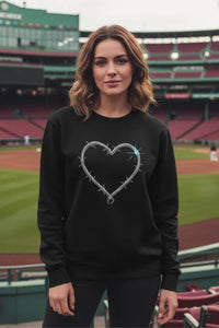 Woman wearing a black sweatshirt with a heart design in a stadium setting