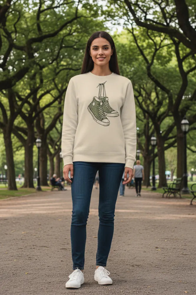 Woman wearing a beige sweatshirt with shoe design in a park