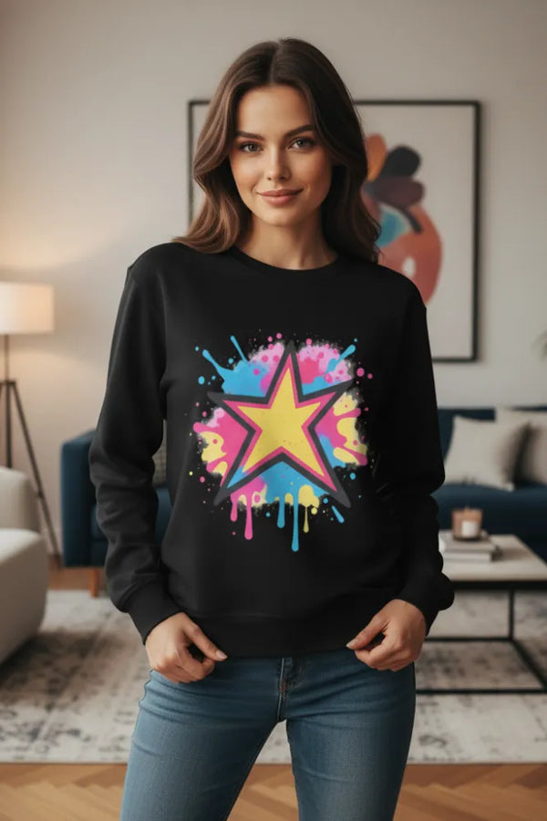 Woman wearing a black sweatshirt with a colorful star design in a living room.