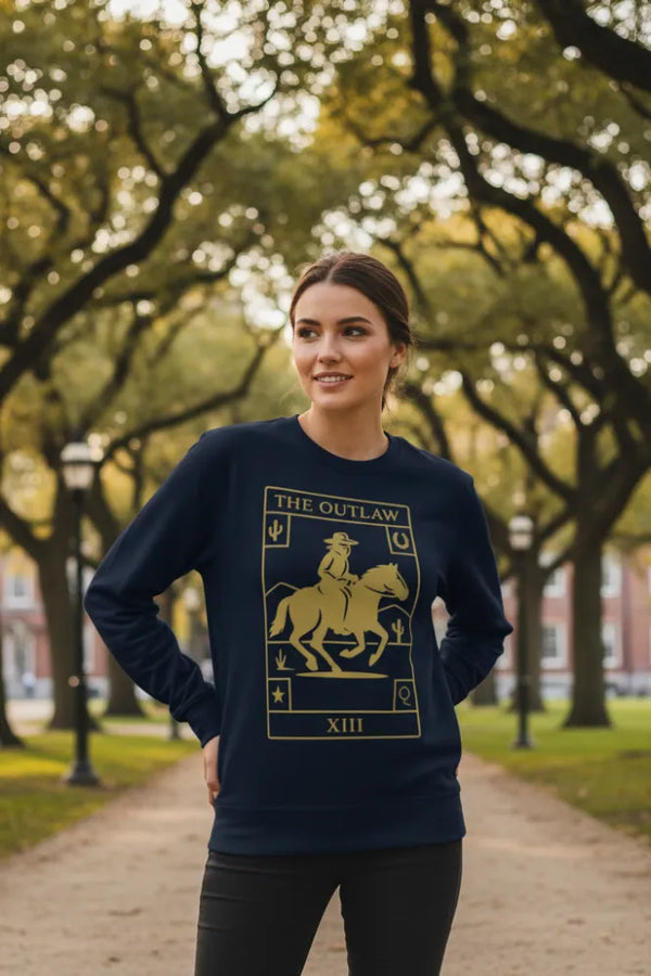 Woman wearing a navy sweatshirt with a gold graphic design in an outdoor setting