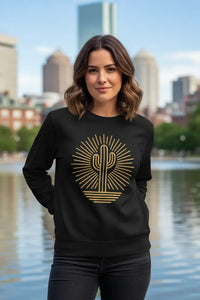 Woman wearing a black sweatshirt with a gold cactus design in an urban setting.
