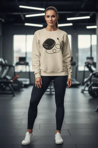 Woman wearing a beige sweatshirt with a graphic design in a gym setting