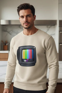 Man wearing a beige sweatshirt with a TV graphic in a kitchen setting