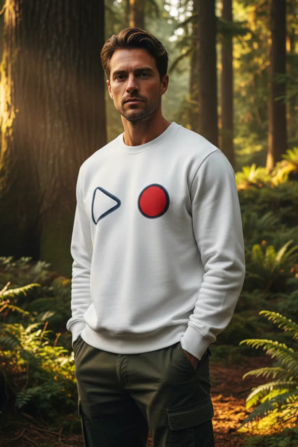 Man wearing a white sweatshirt with abstract designs in a forest setting