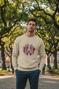 Man wearing a beige sweater with a graphic design in an outdoor setting
