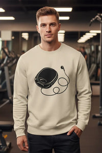 Man wearing a beige sweatshirt with a graphic design in a gym setting