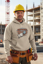 Man wearing a beige hoodie with a graphic design, yellow hard hat, and tool belt on a construction site.