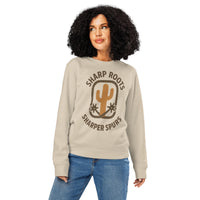 Woman wearing a beige sweatshirt with 'Sharp Roots, Sharper Spurs' text and cactus graphic on a white background