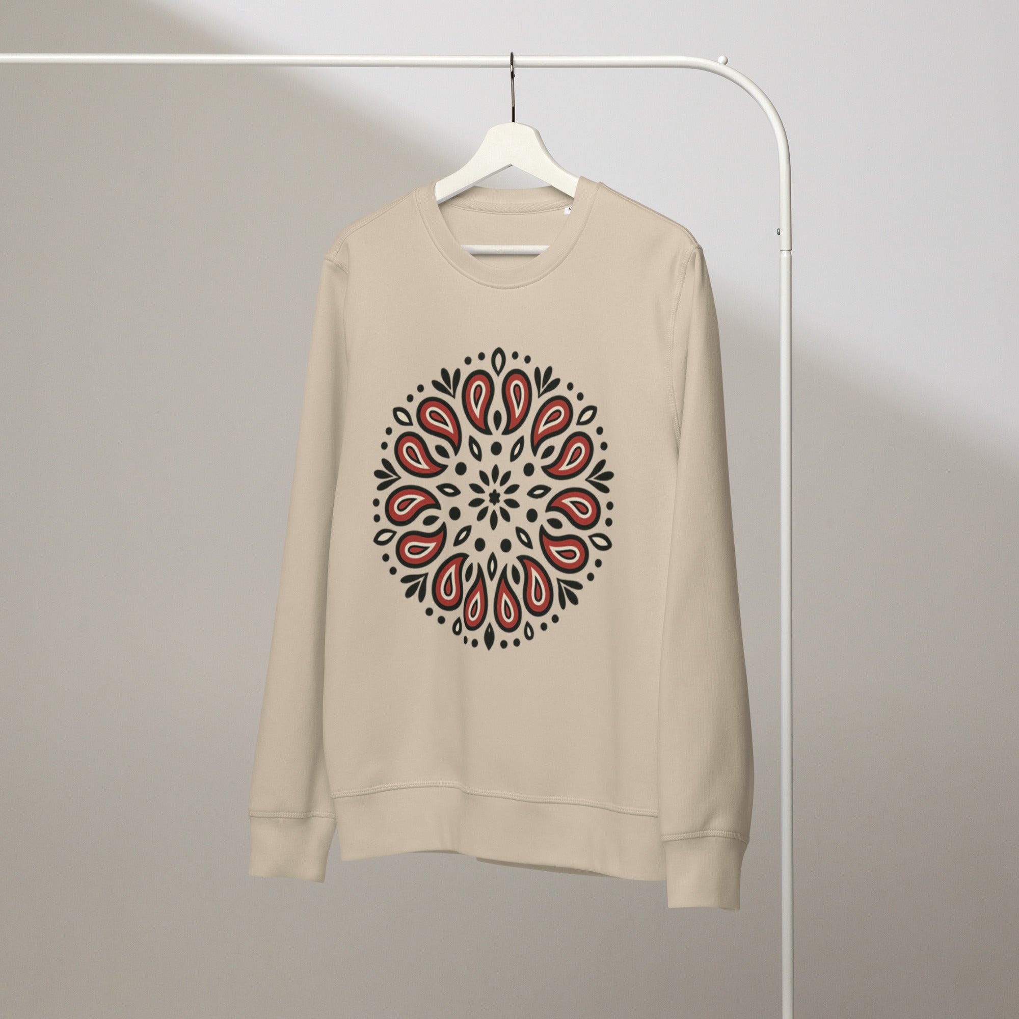 Beige sweatshirt with a red and black paisley pattern on a hanger against a plain background