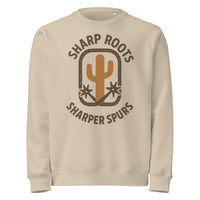 Beige sweatshirt with 'Sharp Roots, Sharper Spurs' graphic on a white background