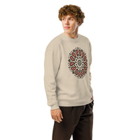 Person wearing a beige sweatshirt with a black and red circular pattern on a white background